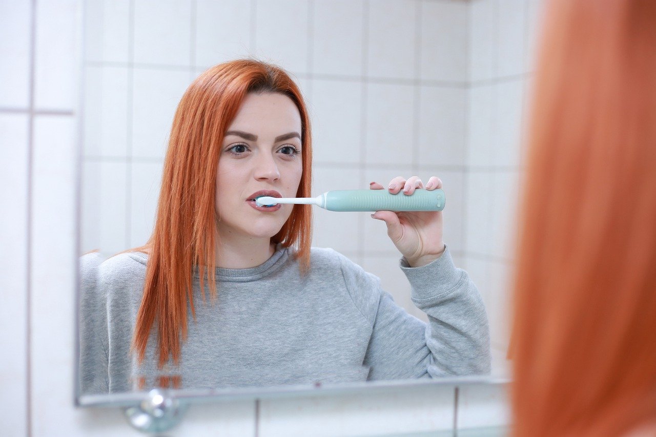 mujer lavandose los dientes para blanquear sus dientes en casa